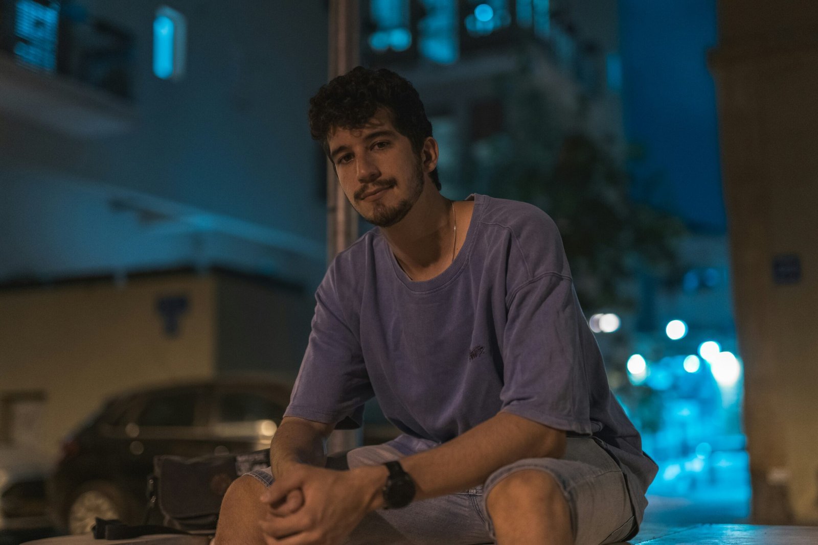 man in gray crew neck t-shirt sitting on brown wooden bench
