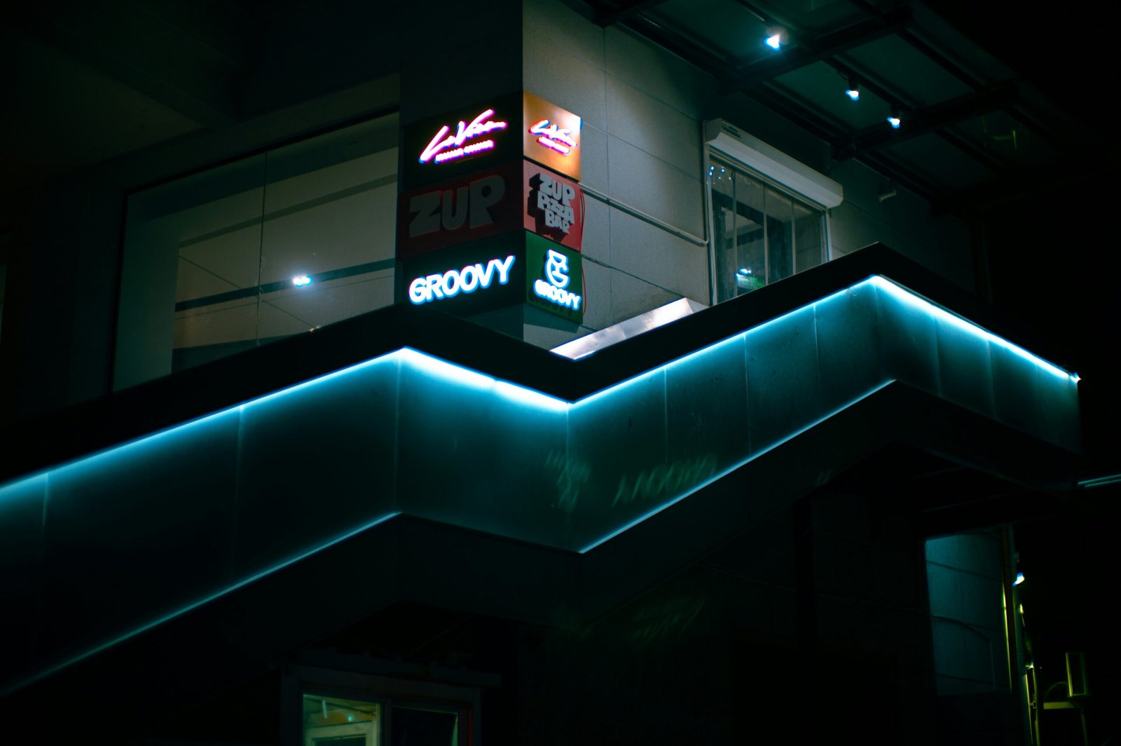 a lit up building with a neon sign above it
