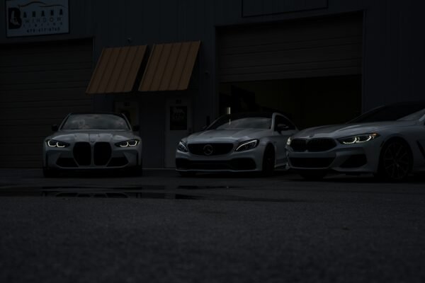 Three cars parked in front of a building at night