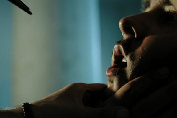 man in black shirt holding his chin