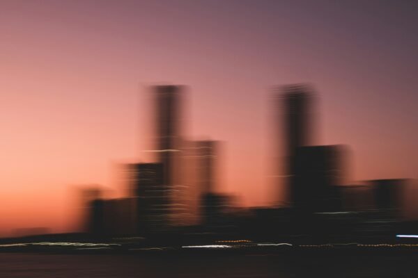 A blurry photo of a city skyline at sunset
