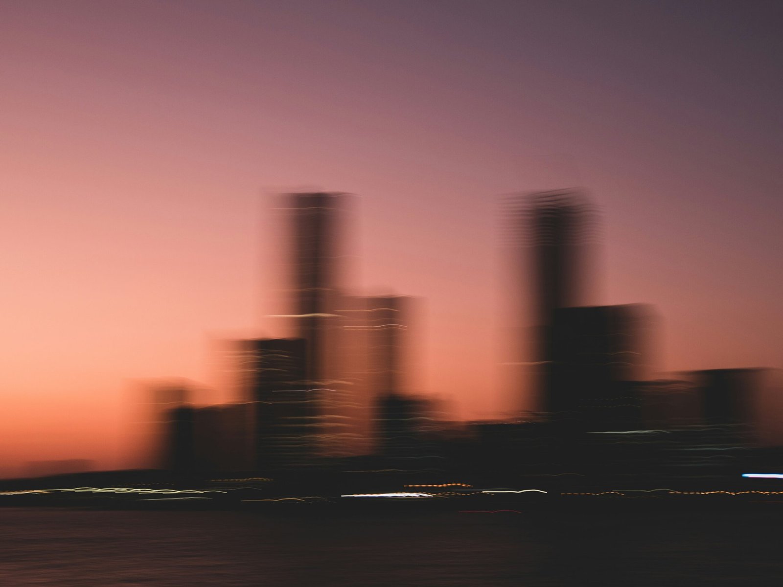 A blurry photo of a city skyline at sunset