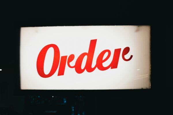 a red order sign hanging from the side of a building