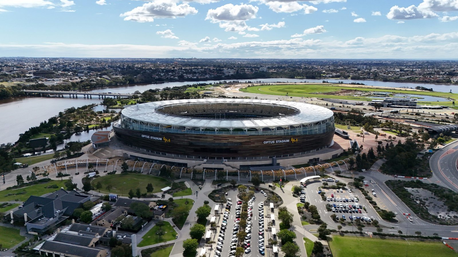 An aerial view of a stadium with a river in the background
