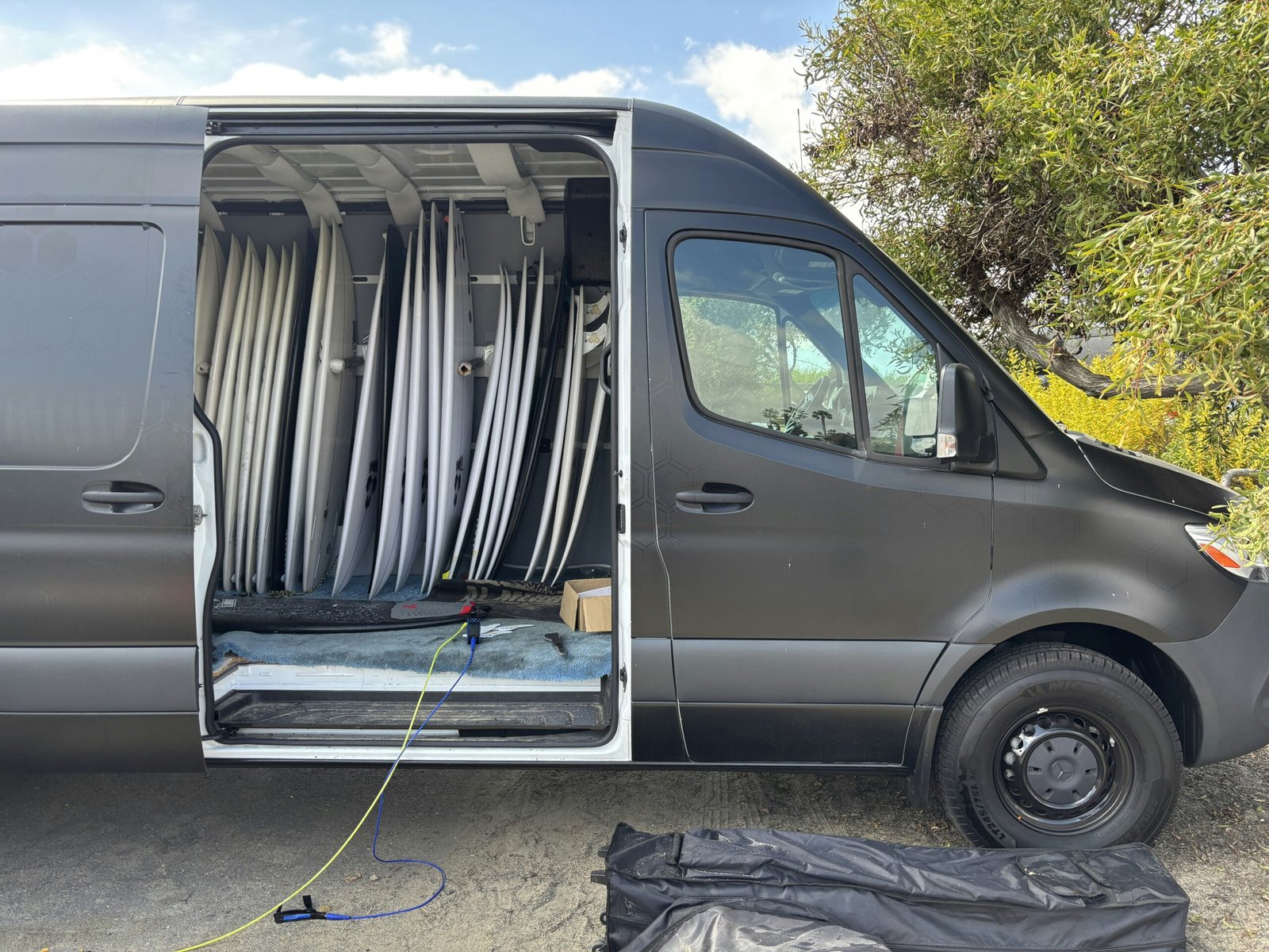 A van is filled with many surfboards.